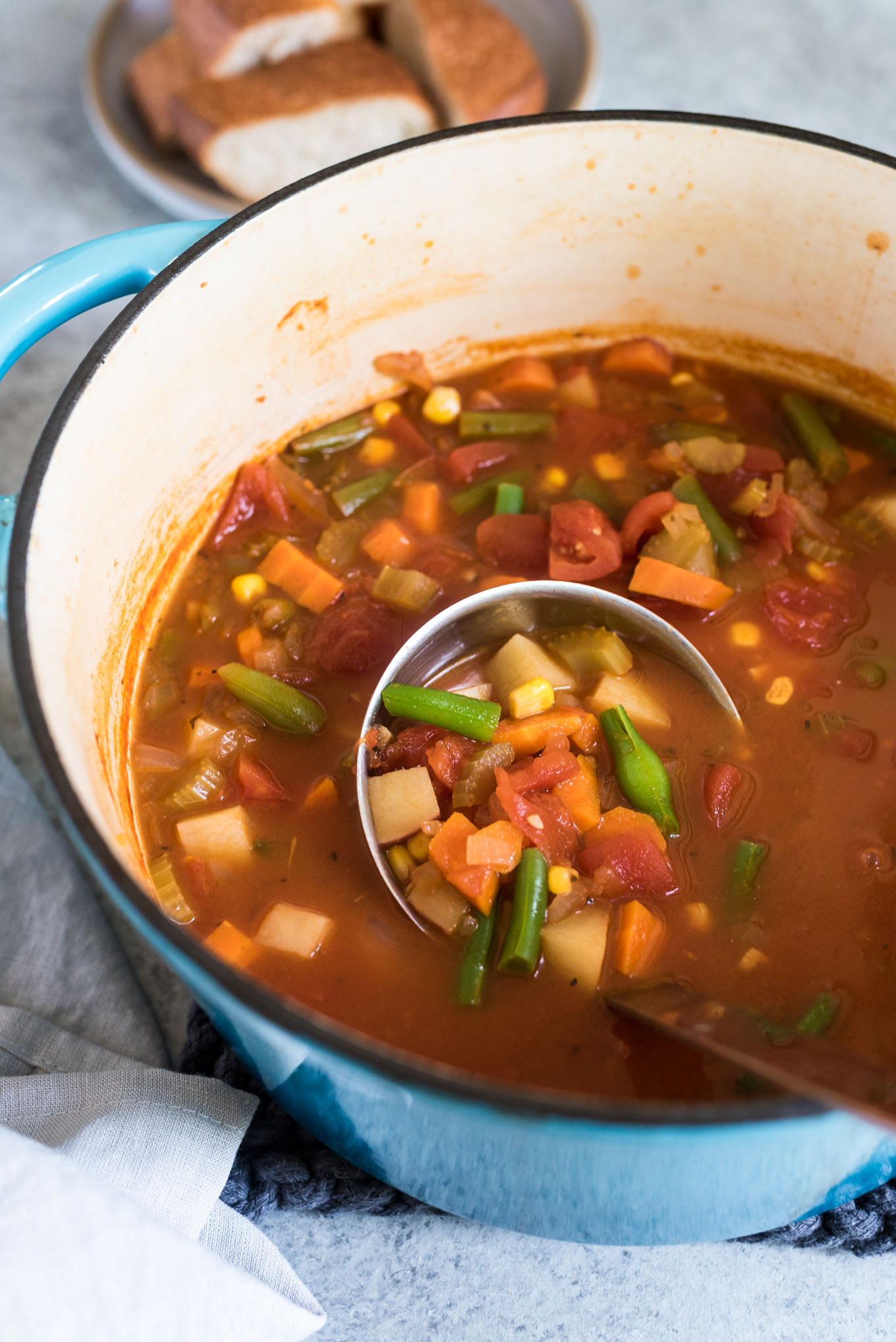 Soup pot with vegetable soup and ladle in it 