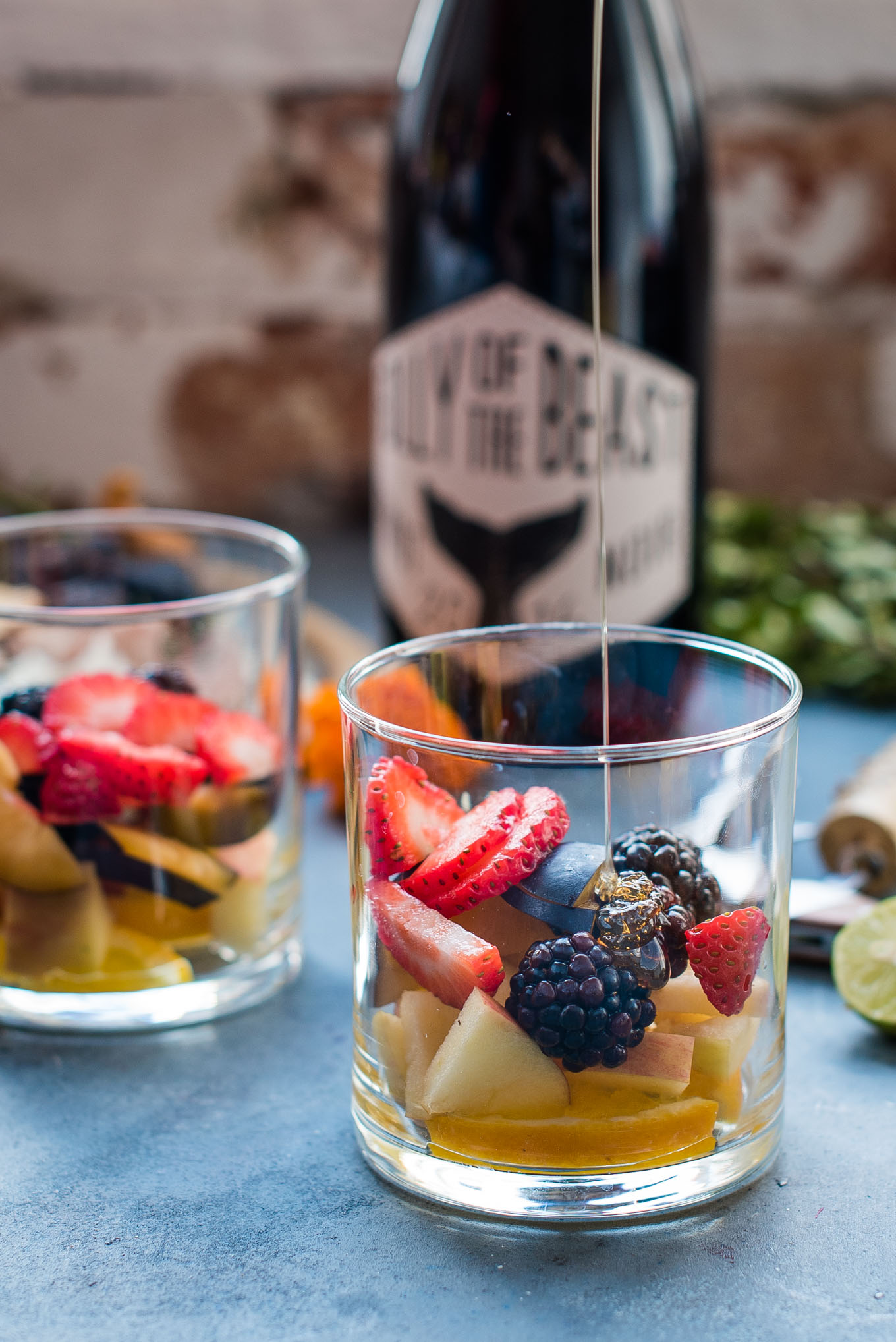 honey being poured into a glass with fruit