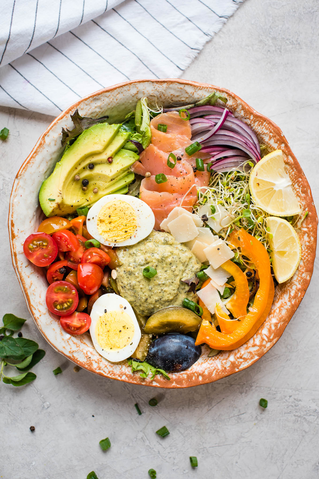 Bowl of vegetables, hummus, egg and salmon