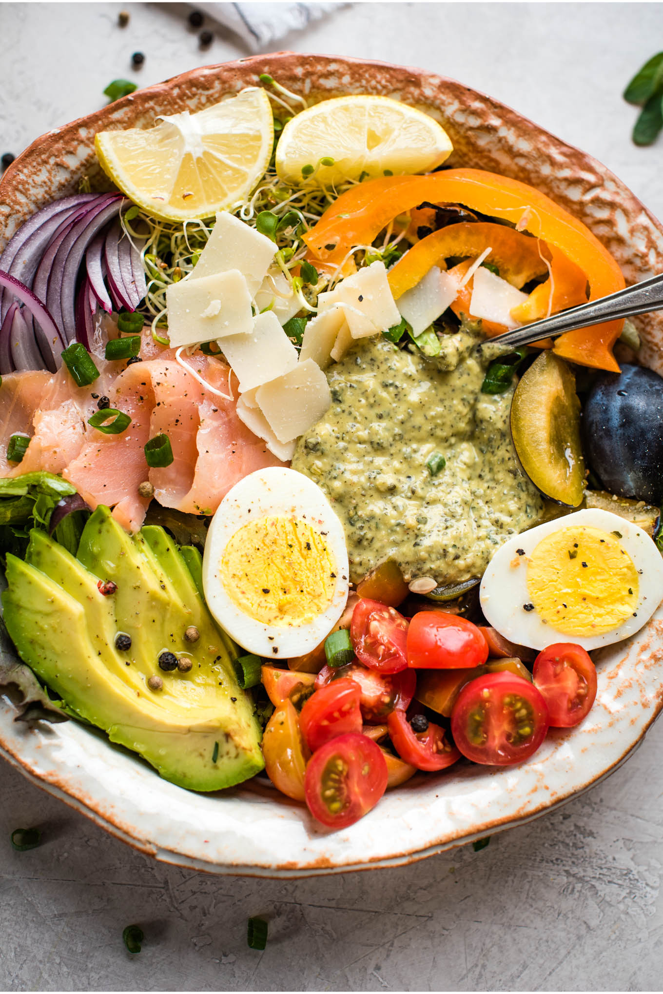 Close up bowl of vegetables, hummus, egg, salmon